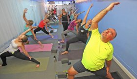 People participate in a yoga class at Warrior Power Yoga in Audubon Park.