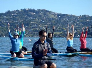 Students practice stand up paddle yoga, known among practitioners as SUP Yoga. Photo: Leigh Claxton
